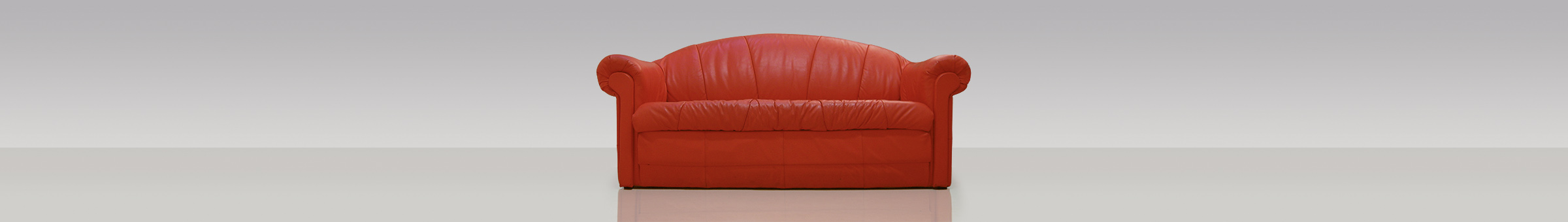 ein rotes Sofa vor neutralem Hintergrund